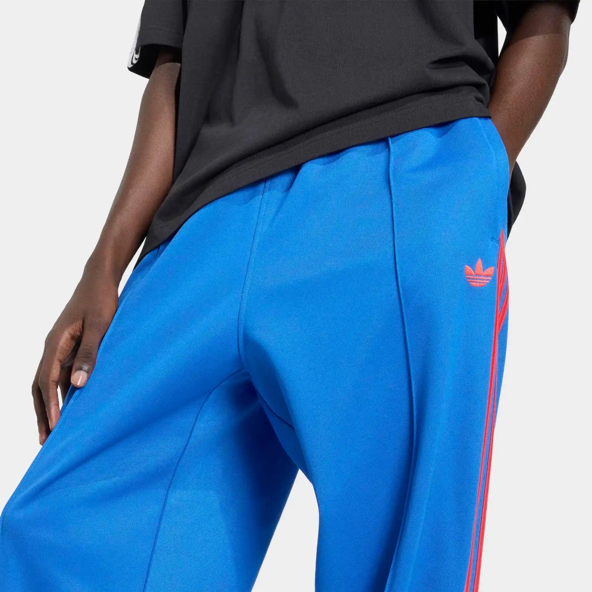 "adidas Originals Firebird Baggy Track Pants Herren in Blau, weiter Oversized-Schnitt, glänzendes Trikot-Material bei Stickabush.“