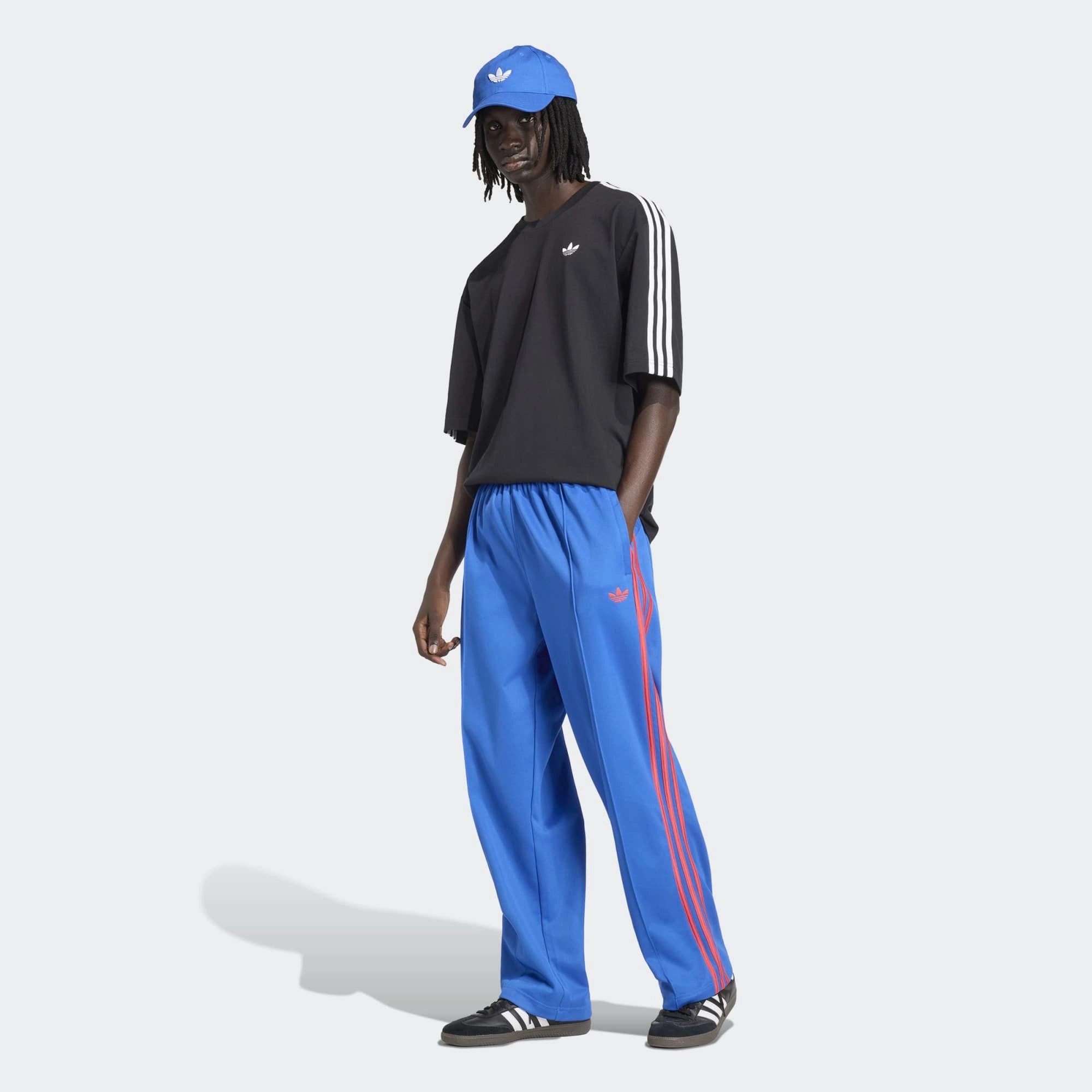 "adidas Originals Firebird Baggy Track Pants Herren in Blau, weiter Oversized-Schnitt, glänzendes Trikot-Material bei Stickabush.“