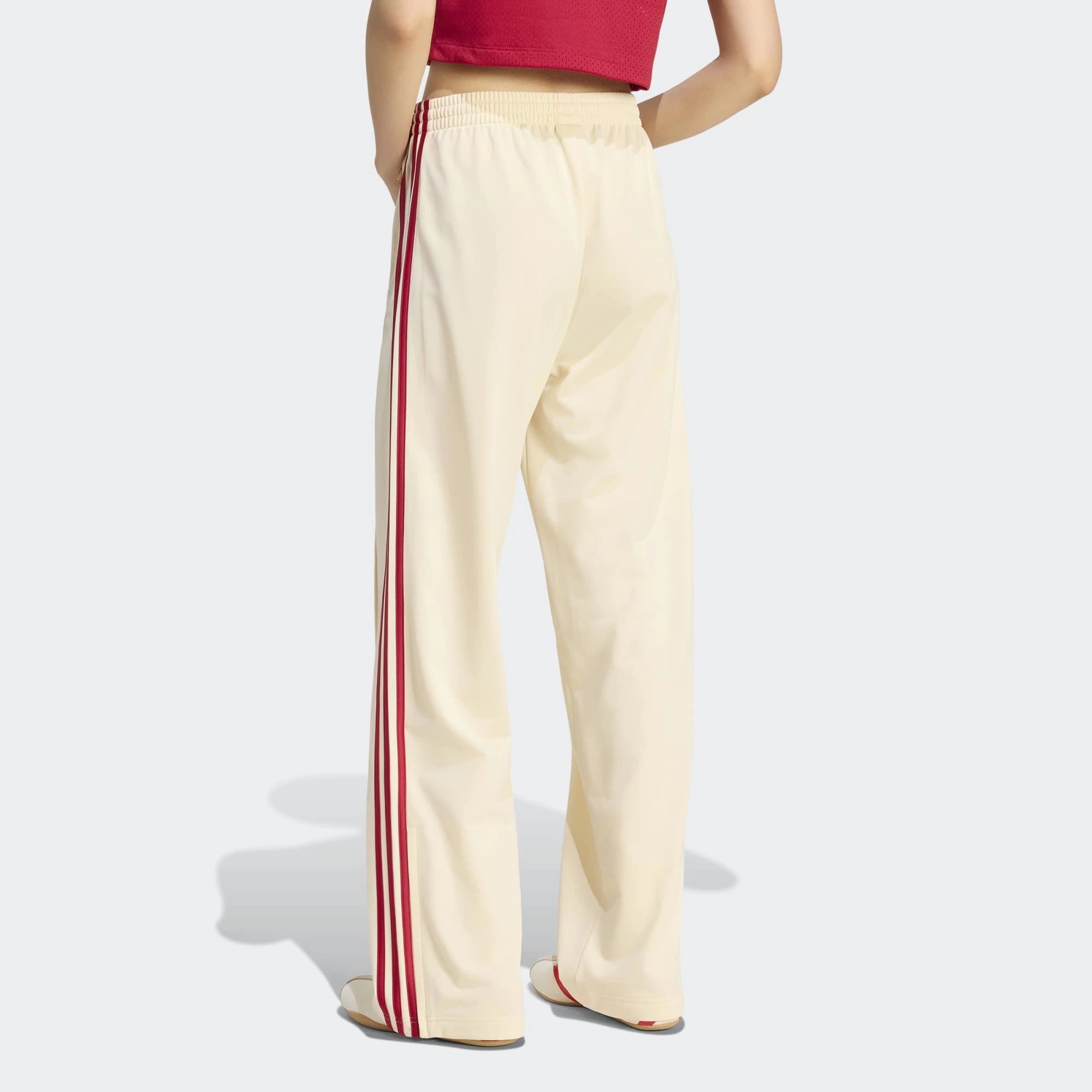 “adidas Originals Firebird Loose Damen Trainingshose in hellem Vanilla-Weiß mit roten drei Streifen und Trefoil-Logo bei Stickabush Berlin.“ 
