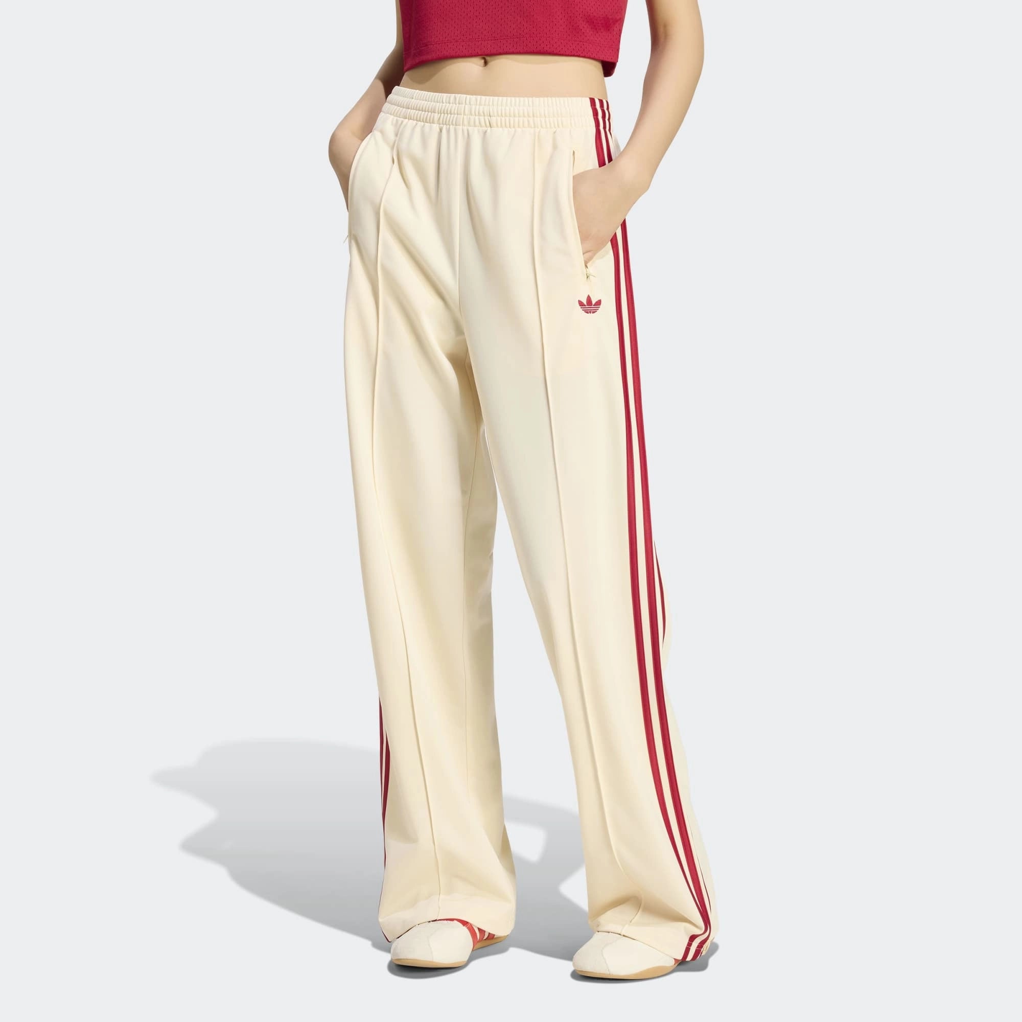 “adidas Originals Firebird Loose Damen Trainingshose in hellem Vanilla-Weiß mit roten drei Streifen und Trefoil-Logo bei Stickabush Berlin.“ 