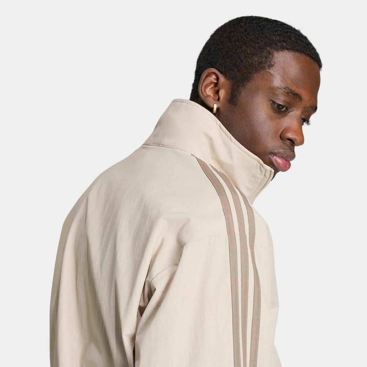 adidas Originals Firebird Woven Track Top in Beige Details am Model von der Seite, hochauflösend präsentiert im STICKABUSH Store Berlin.