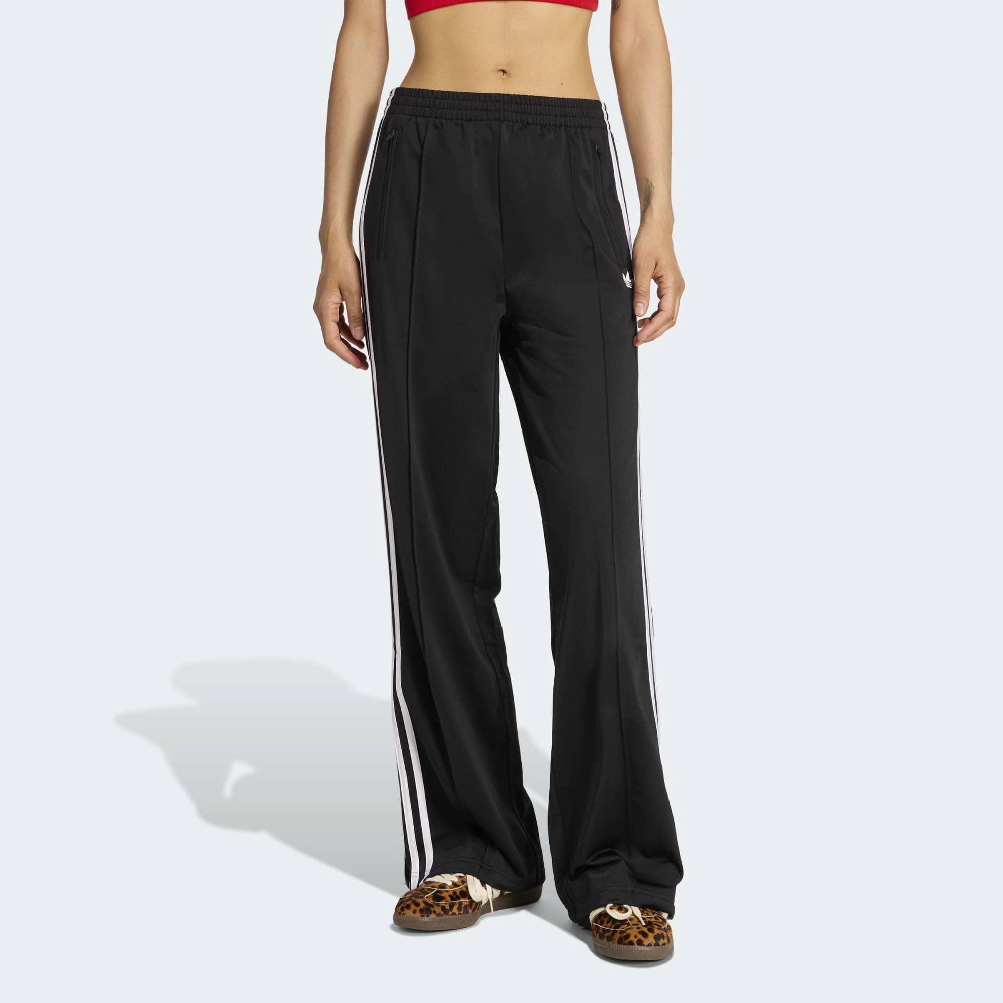 „Schwarze adidas Originals Firebird Loose Track Pants für Damen mit weißen 3-Streifen (Style-ID: KD7976) – weit geschnittene Streetwear-Trainingshose aus Trikot-Stoff bei Stickabush Berlin.“