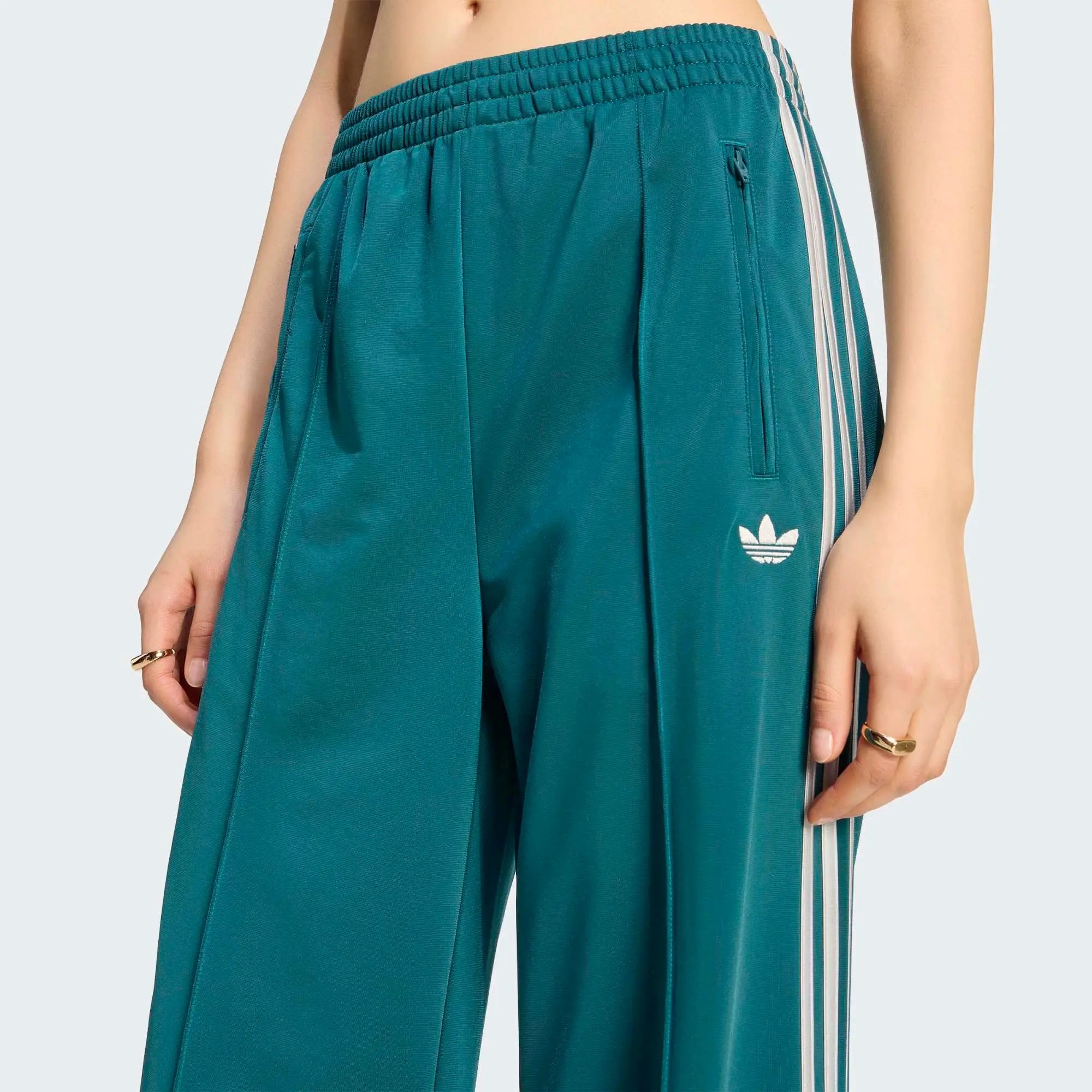 „Dunkelgrüne adidas Originals Firebird Loose Damen Track Pants (KS4672) mit grauen Streifen – weit geschnittene Retro-Trainingshose erhältlich bei Stickabush Berlin.“