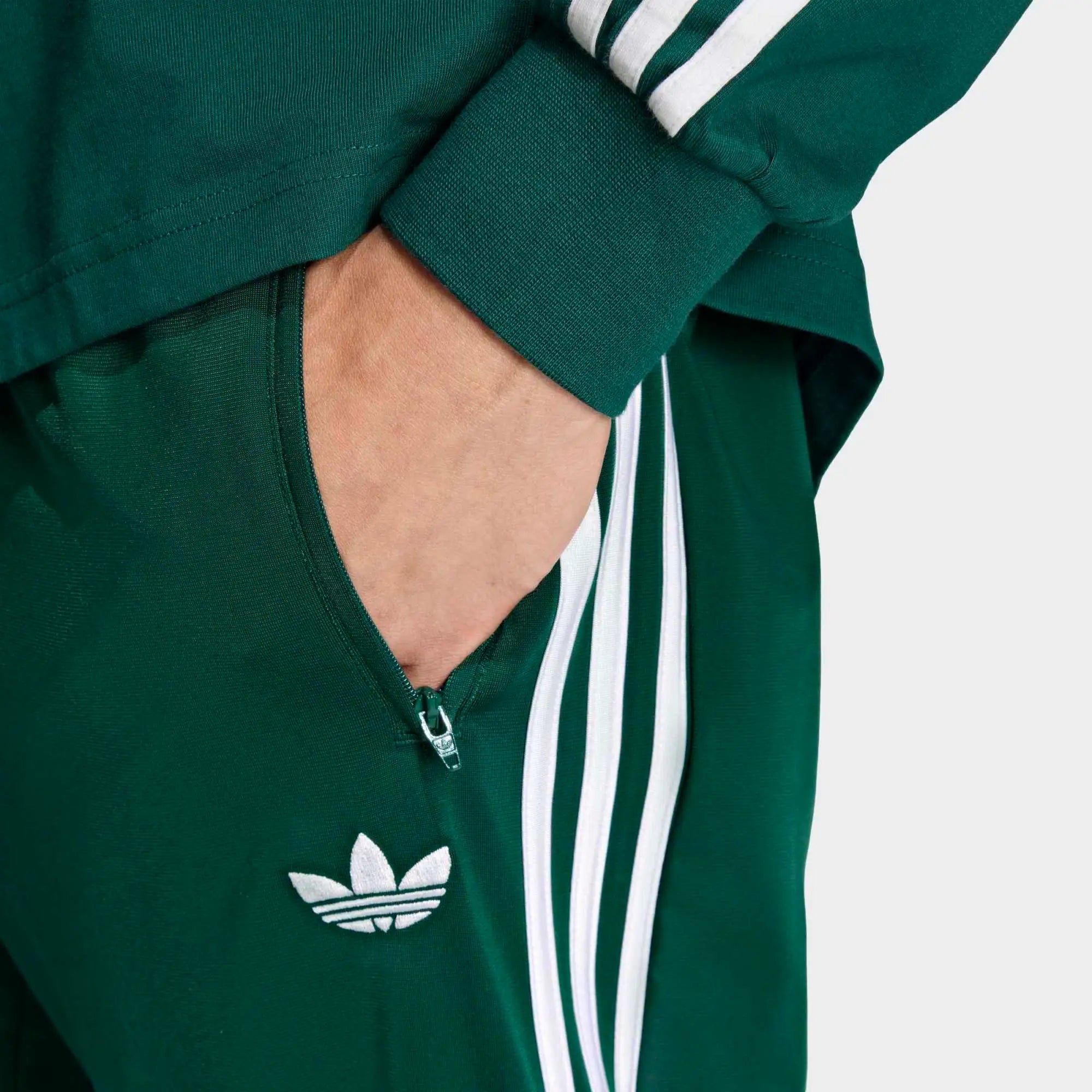 „Dunkelgrüne adidas Originals Firebird Damen Track Pants (KD8317) in Collegiate Green mit weißen Streifen – klassische Retro-Trainingshose erhältlich bei Stickabush Berlin.“