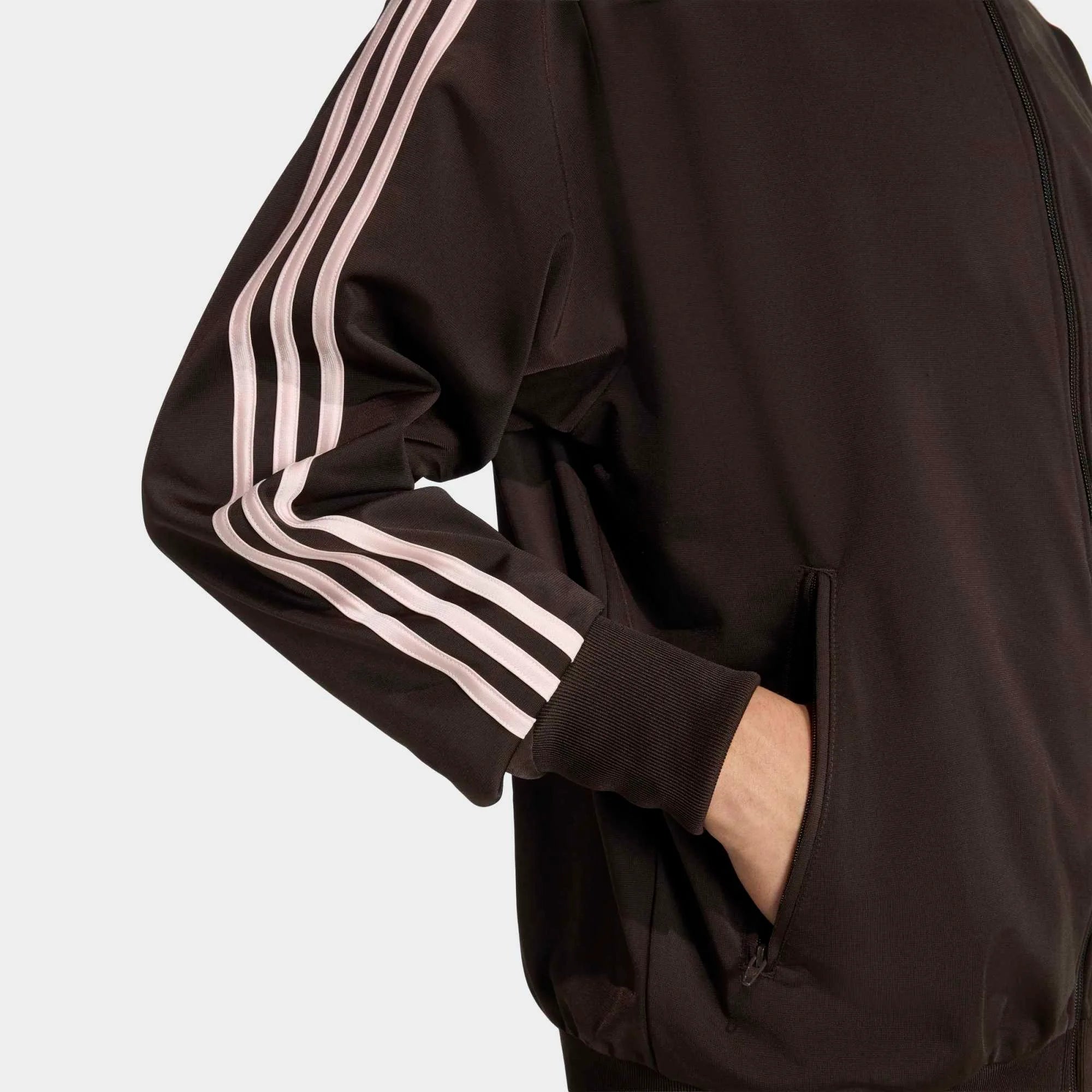 “Die braune adidas Originals Firebird Trainingsjacke in Aurora Coffee mit altrosa farbenen 3-Streifen und Stehkragen im Retro-Look bei Stickabush“.