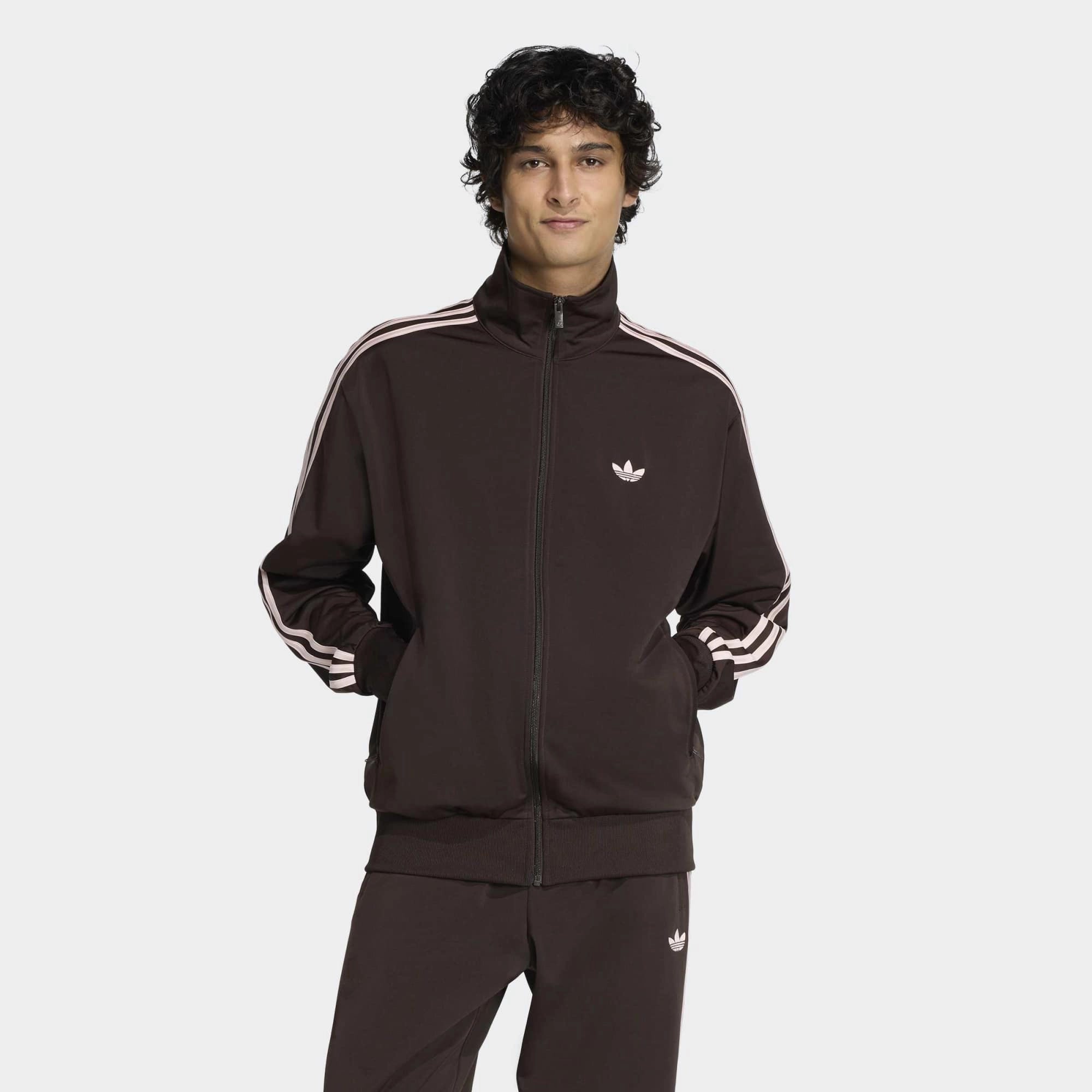 “Die braune adidas Originals Firebird Trainingsjacke in Aurora Coffee mit altrosa farbenen 3-Streifen und Stehkragen im Retro-Look bei Stickabush“.