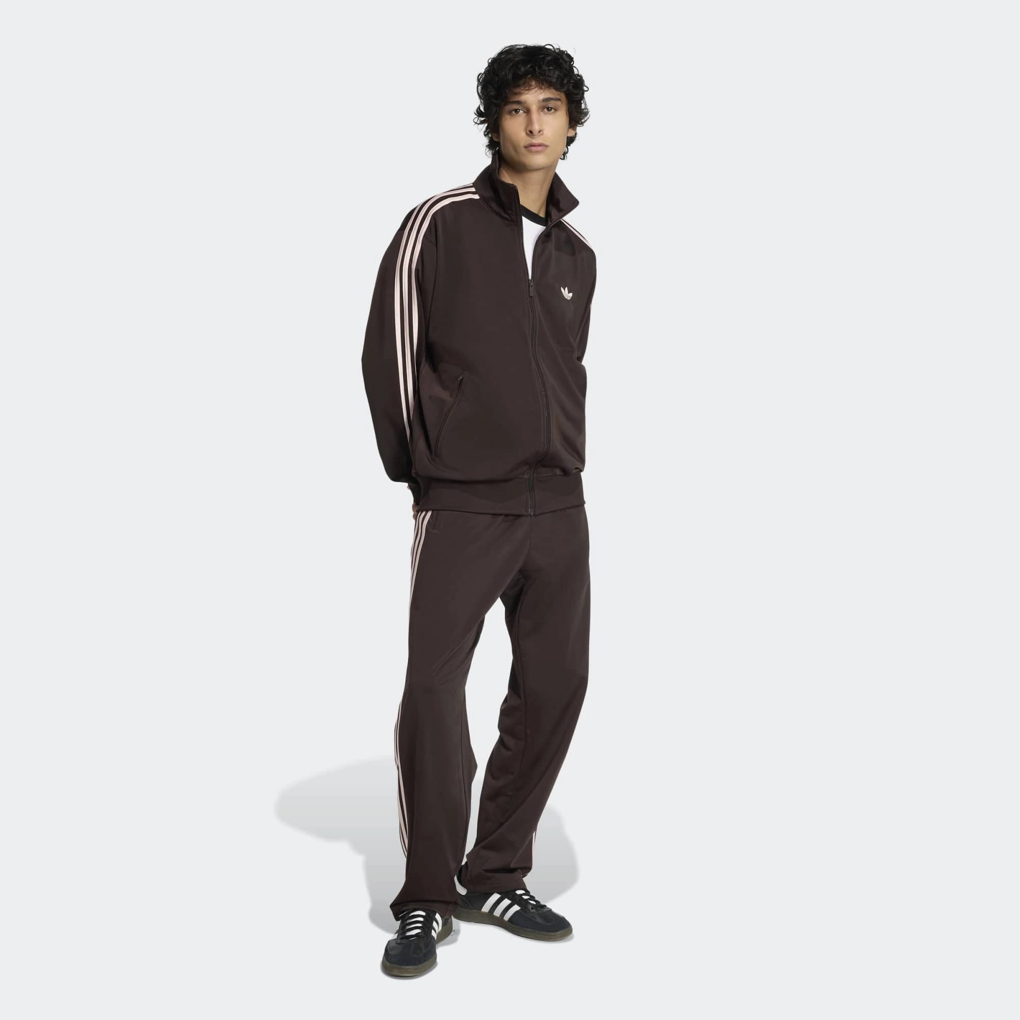 “Die braune adidas Originals Firebird Trainingsjacke in Aurora Coffee mit altrosa farbenen 3-Streifen und Stehkragen im Retro-Look bei Stickabush“.