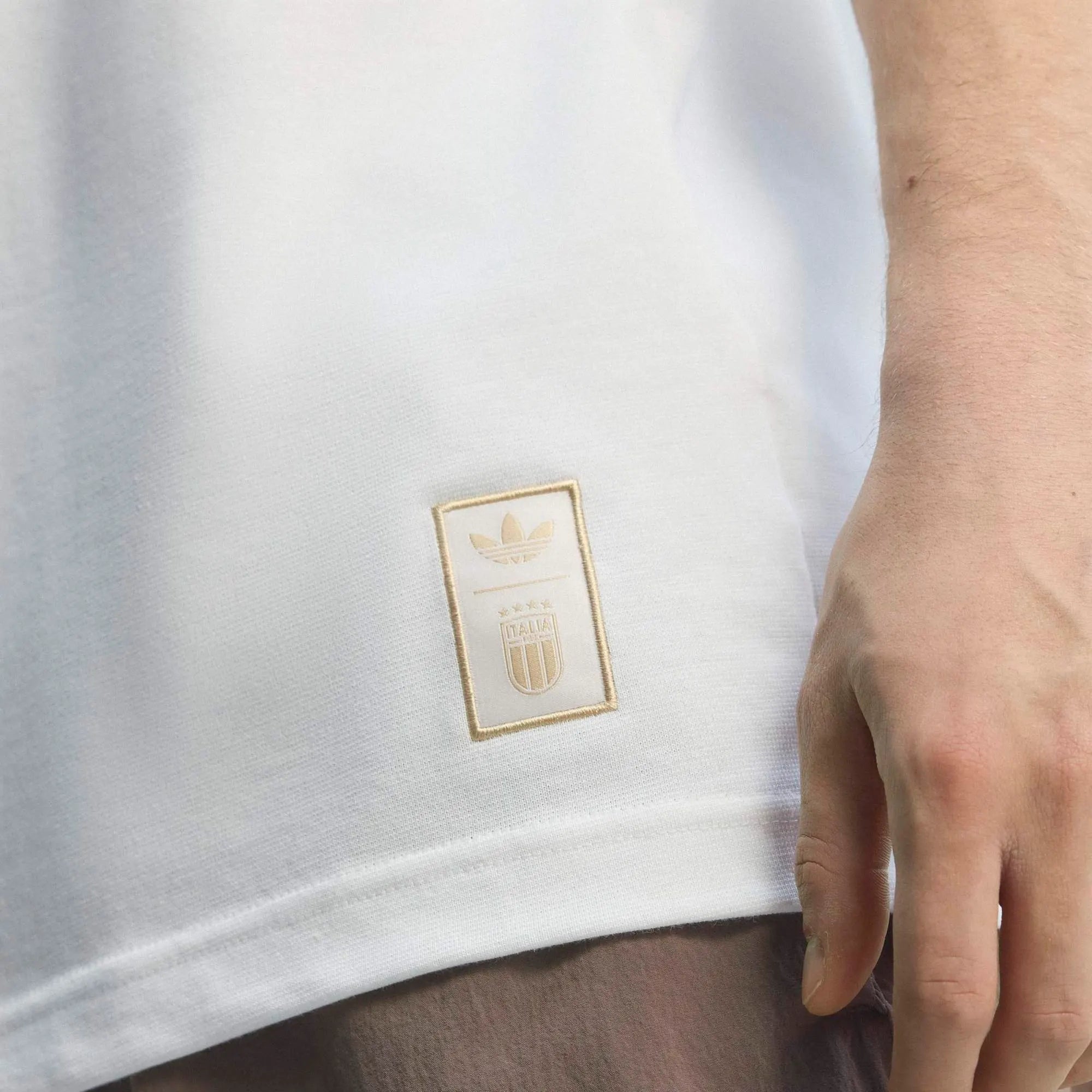 “adidas Originals Italien OG T-Shirts in Crystal White (KC6611) mit den klassischen blauen Streifen auf den Schultern, dem Italien-Wappen und dem blauen Trefoil-Logo auf der Brust bei Stickabush Berlin.“