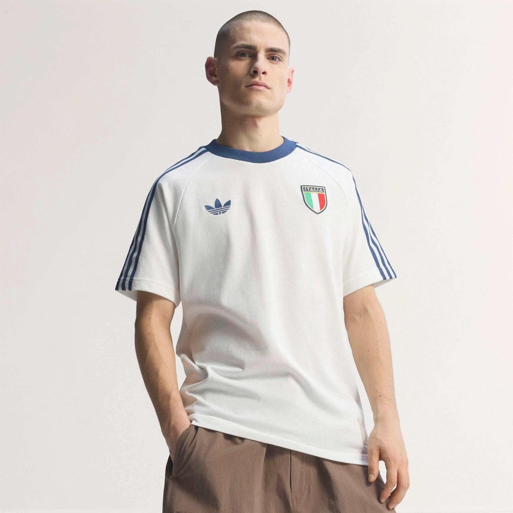 “adidas Originals Italien OG T-Shirts in Crystal White (KC6611) mit den klassischen blauen Streifen auf den Schultern, dem Italien-Wappen und dem blauen Trefoil-Logo auf der Brust bei Stickabush Berlin.“