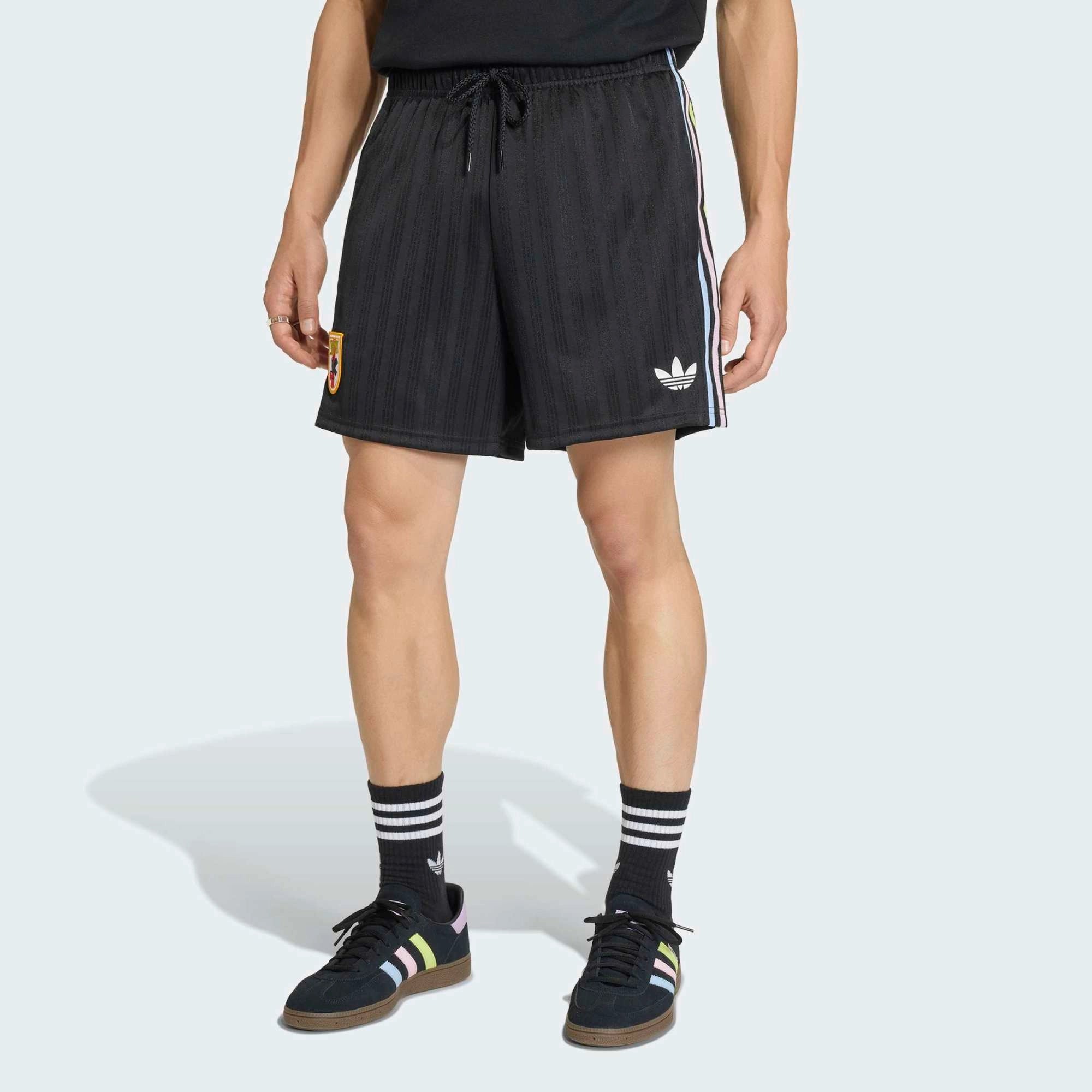 “Schwarze adidas Originals Japan OG Shorts mit weißen Streifen und dem gestickten JFA Japan Verbandswappen bei Stickabush.“