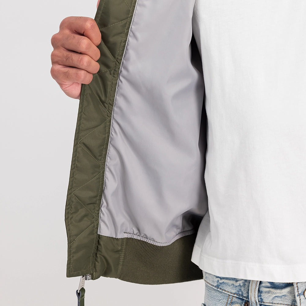 Alpha Industries CWU-36/P TT Light Bomberjacke in Dark Olive (266101-142) mit „Remove Before Flight“ Tag bei Stickabush Berlin.