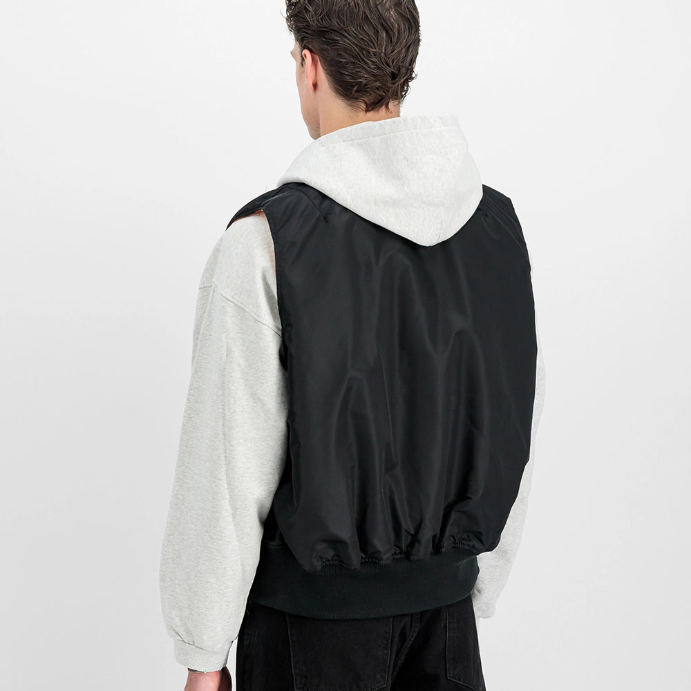 Schwarze Alpha Industries MA-1 Vest Heritage für Herren mit dem ikonischen roten Remove Before Flight Tag und orangenem Innenfutter bei Stickabush Berlin.