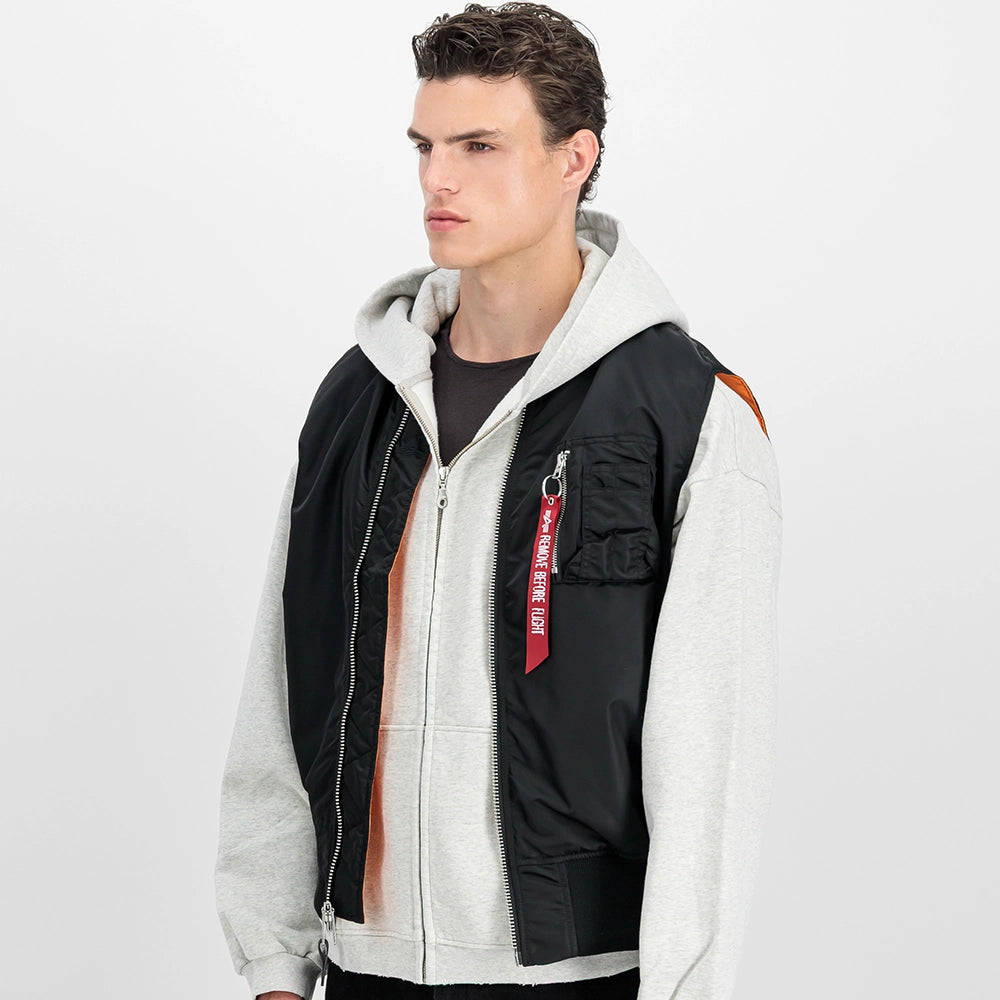 Schwarze Alpha Industries MA-1 Vest Heritage für Herren mit dem ikonischen roten Remove Before Flight Tag und orangenem Innenfutter bei Stickabush Berlin.