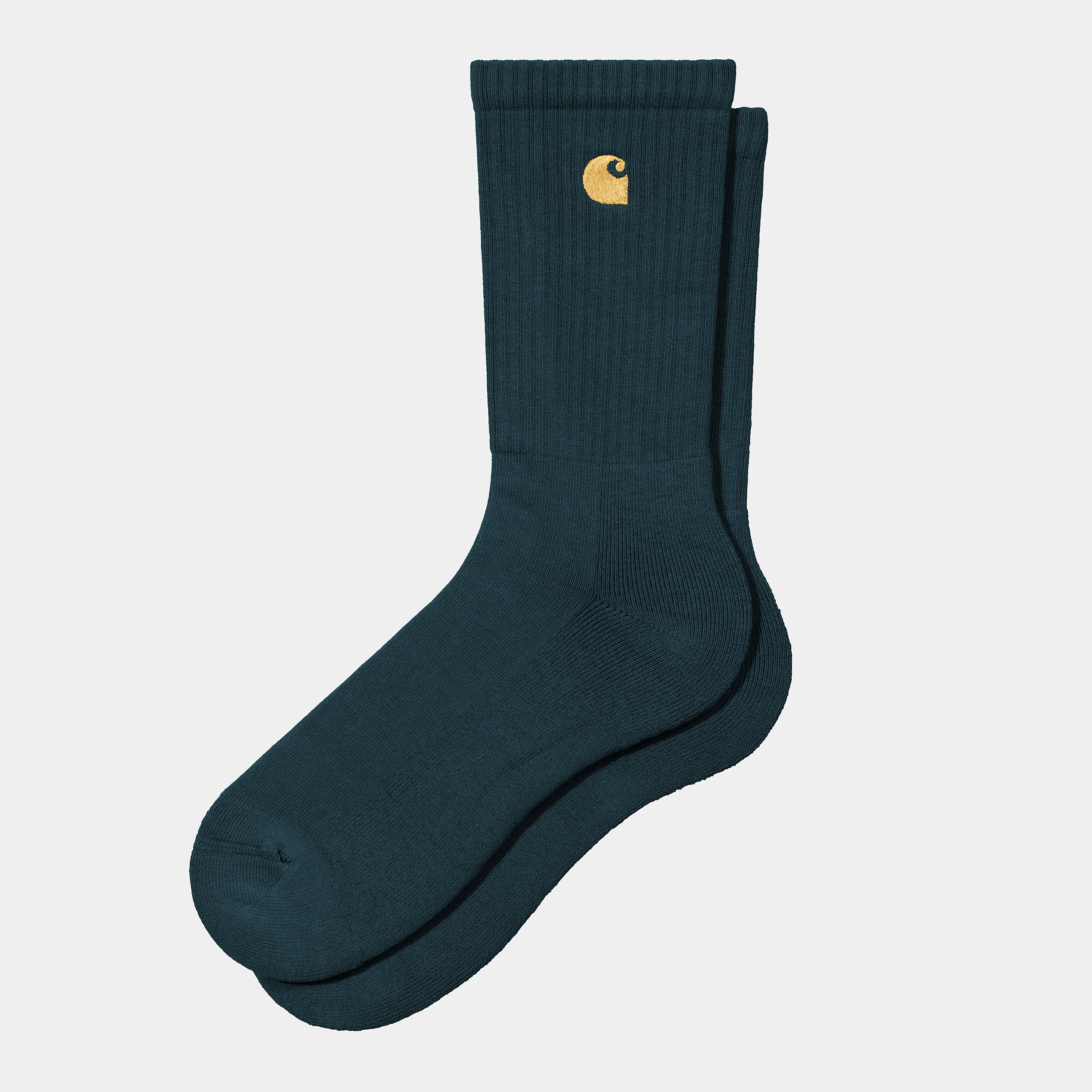 “Carhartt WIP Chase Socks – Duck Blue / Gold. Dunkelblaue Socken aus Baumwollmischung, mit geripptem Schaft und goldenem Carhartt "C" Logo-Stick.“