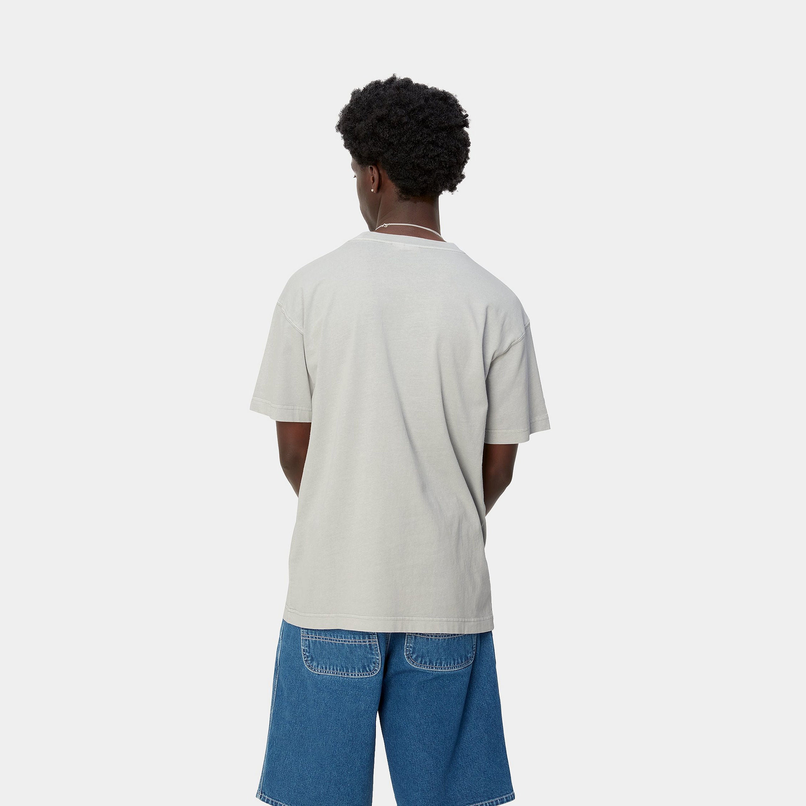 "Helles, silbergraues ("Sonic Silver") Carhartt WIP S/S Nelson T-Shirt. Kurzärmliges Herren-T-Shirt aus weichem, stückgefärbtem Baumwolljersey. Lockere Passform, gerippter Rundhalsausschnitt, kleines gewebtes Carhartt Square Label auf der Brust. Bequemes Basic für jeden Tag."
