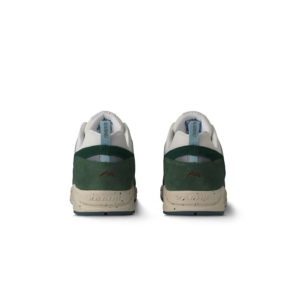 „Der Karhu Fusion 2.0 Mölkky Pack in Laurel Wreath / Blanc de Blanc ist ein Retro-Sneaker mit dunkel- und hellgrünen Elementen, beigen Akzenten und einer beigen Sohle. An der Seite befindet sich das elegante Karhu-Branding.“ 