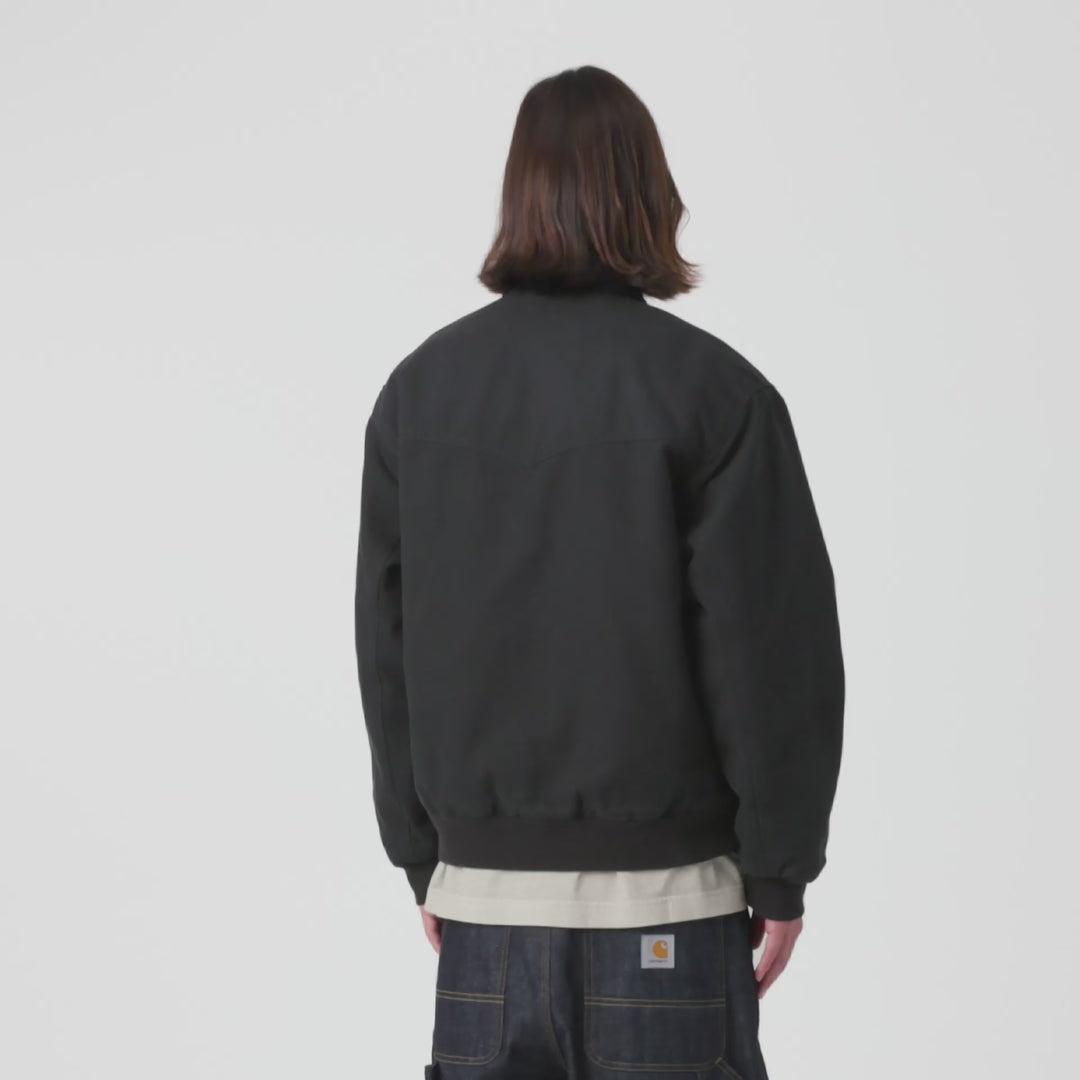 Carhartt WIP OG Santa Fe Jacket in Black / Black – Video mit Model der schwarzen Stone-Canvas-Workwear-Jacke mit farblich abgesetzten Cord-Details und Reißverschlusstasche.