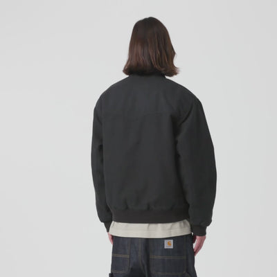 Carhartt WIP OG Santa Fe Jacket in Black / Black – Video mit Model der schwarzen Stone-Canvas-Workwear-Jacke mit farblich abgesetzten Cord-Details und Reißverschlusstasche.