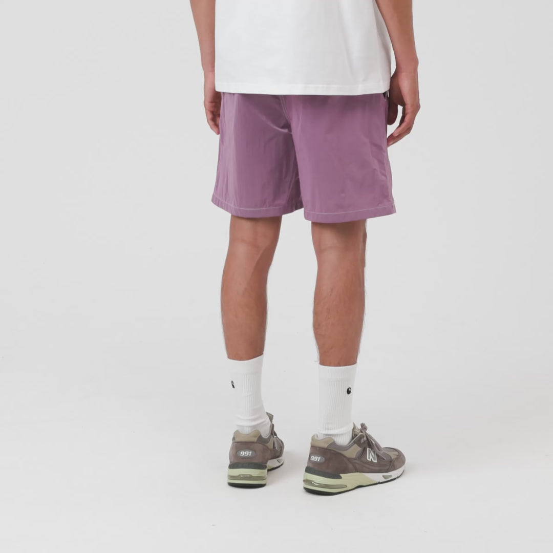“Video von der Carhartt WIP Canby Swim Trunks in Gentle Purple Lila mit weißem Logo-Schriftzug, lässige Badehose mit Mesh-Innentasche bei Stickabush Berlin.“ 