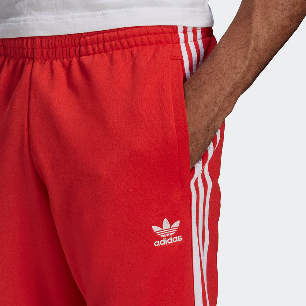 "Rote adidas Classics SST Track Pant mit weißen 3-Streifen und Trefoil-Logo, schmal zulaufendes Bein mit Rippbündchen bei Stickabush Berlin."