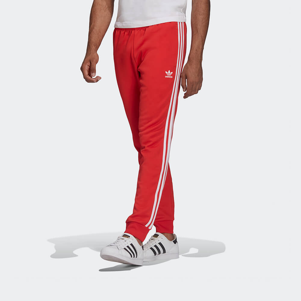 "Rote adidas Classics SST Track Pant mit weißen 3-Streifen und Trefoil-Logo, schmal zulaufendes Bein mit Rippbündchen bei Stickabush Berlin."