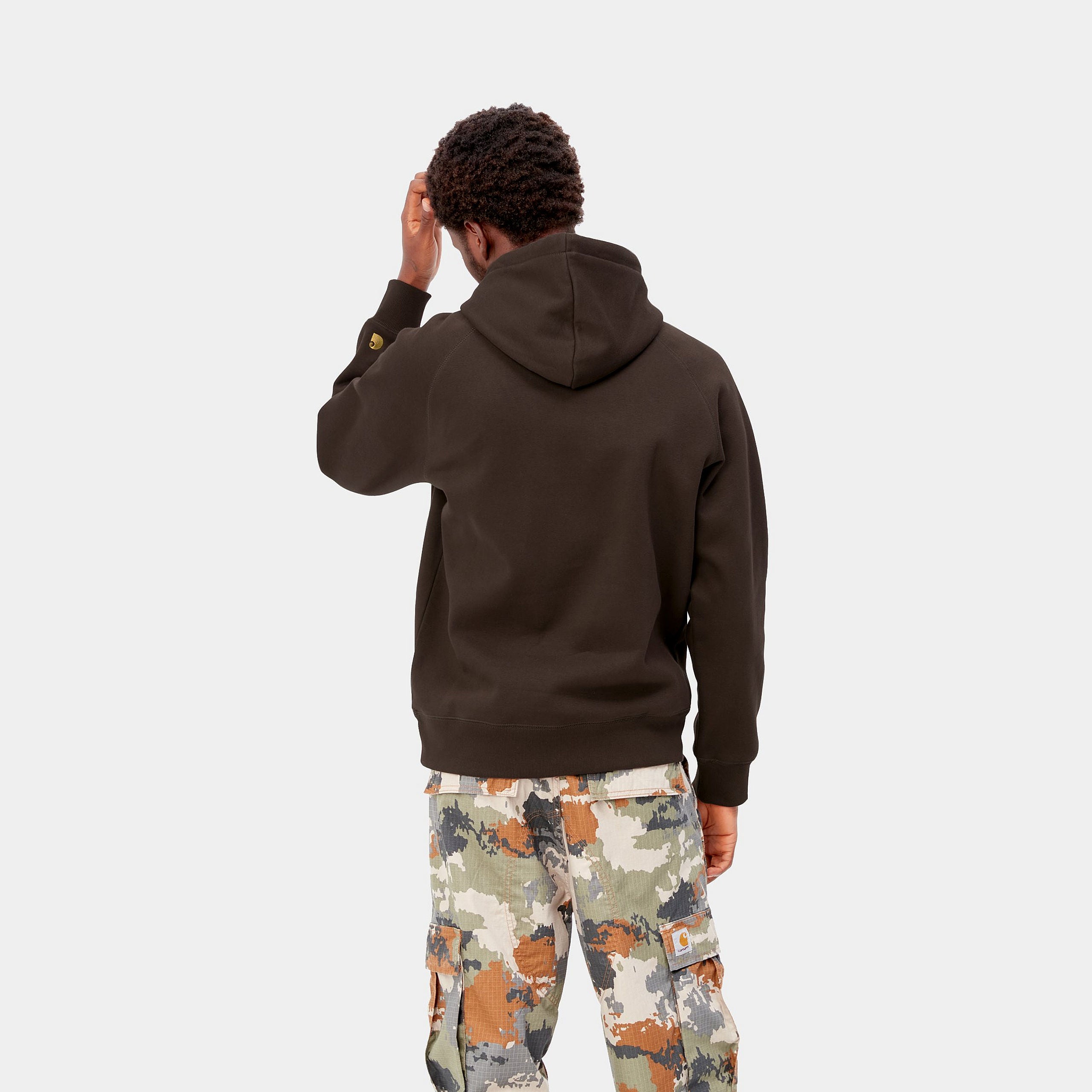 „Carhartt WIP Chase Hoodie in Dark Umber. Dunkelbrauner Kapuzenpullover aus Baumwoll-Jersey, mit Kängurutasche, Bündchen und gesticktem Carhartt Logo am Ärmel bei Stickabush Berlin.“