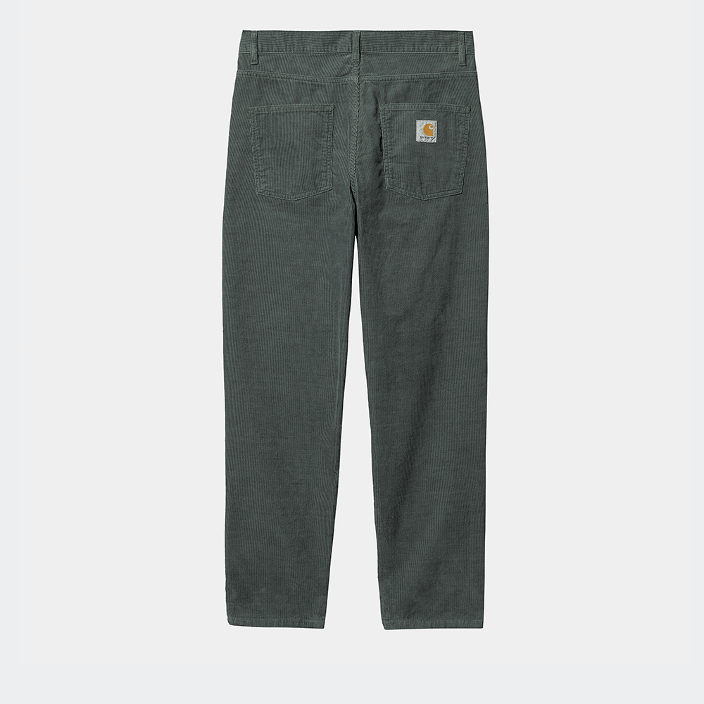 “Carhartt WIP Newel Pant in Jura-Grün, aus robustem Baumwoll-Twill, Cordhose mit lockerer Passform und gewebtem Logo-Patch auf der Gesäßtasche.“